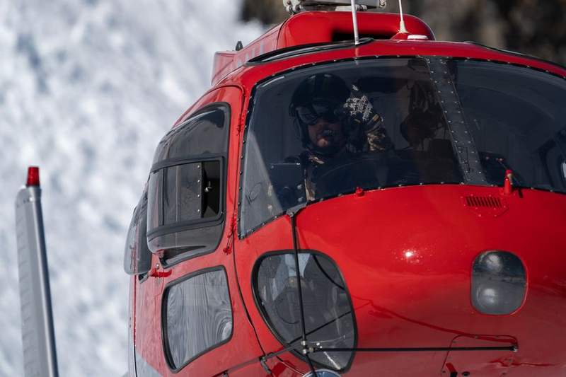 Helicopter on a winter landing zone with crew alongside