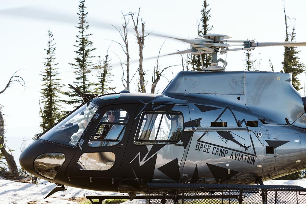 Base Camp Aviation helicopter on a mountain landing zone, crew aboard