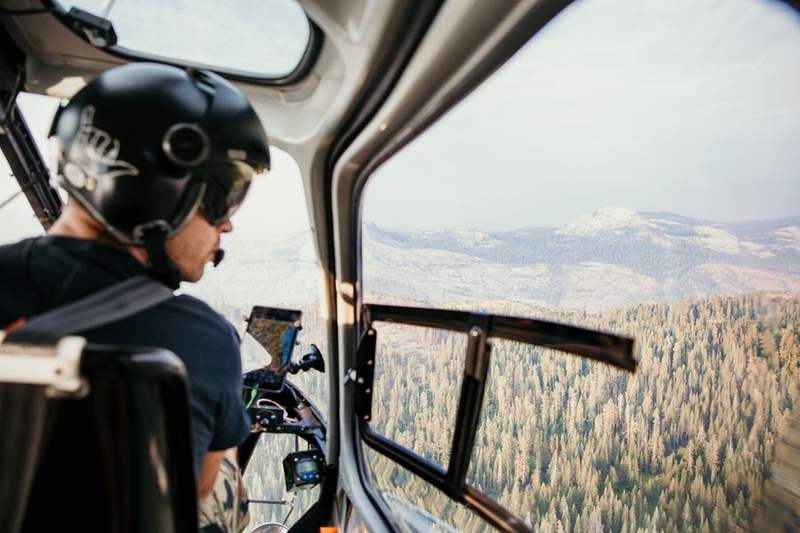 Pilot flying a low-level patrol line over forested terrain