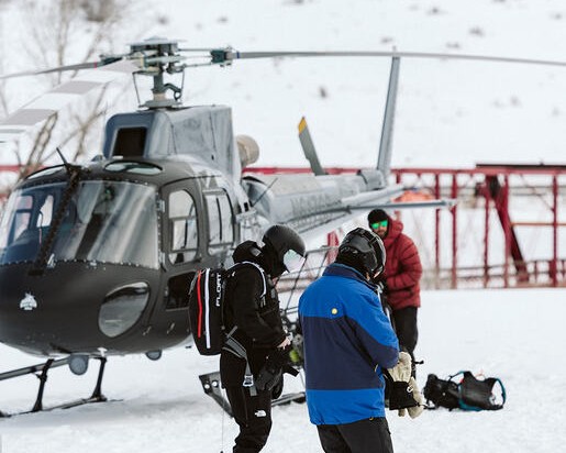 Guests gearing up beside the helicopter on the snow